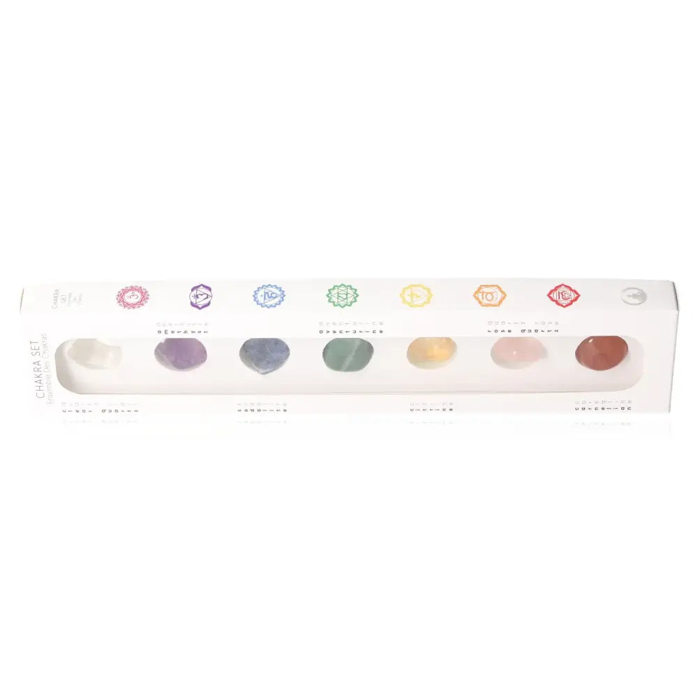 Set of colorful chakra stones in a white package, each representing a different chakra for spiritual and healing purposes.