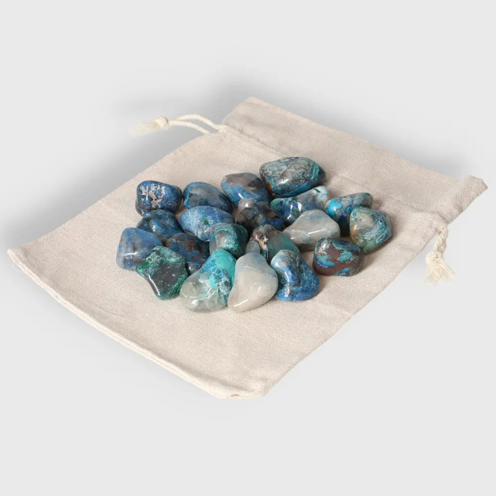 Collection of polished Shattuckite stones in a beige drawstring pouch, highlighting spiritual healing and Heart Chakra activation.