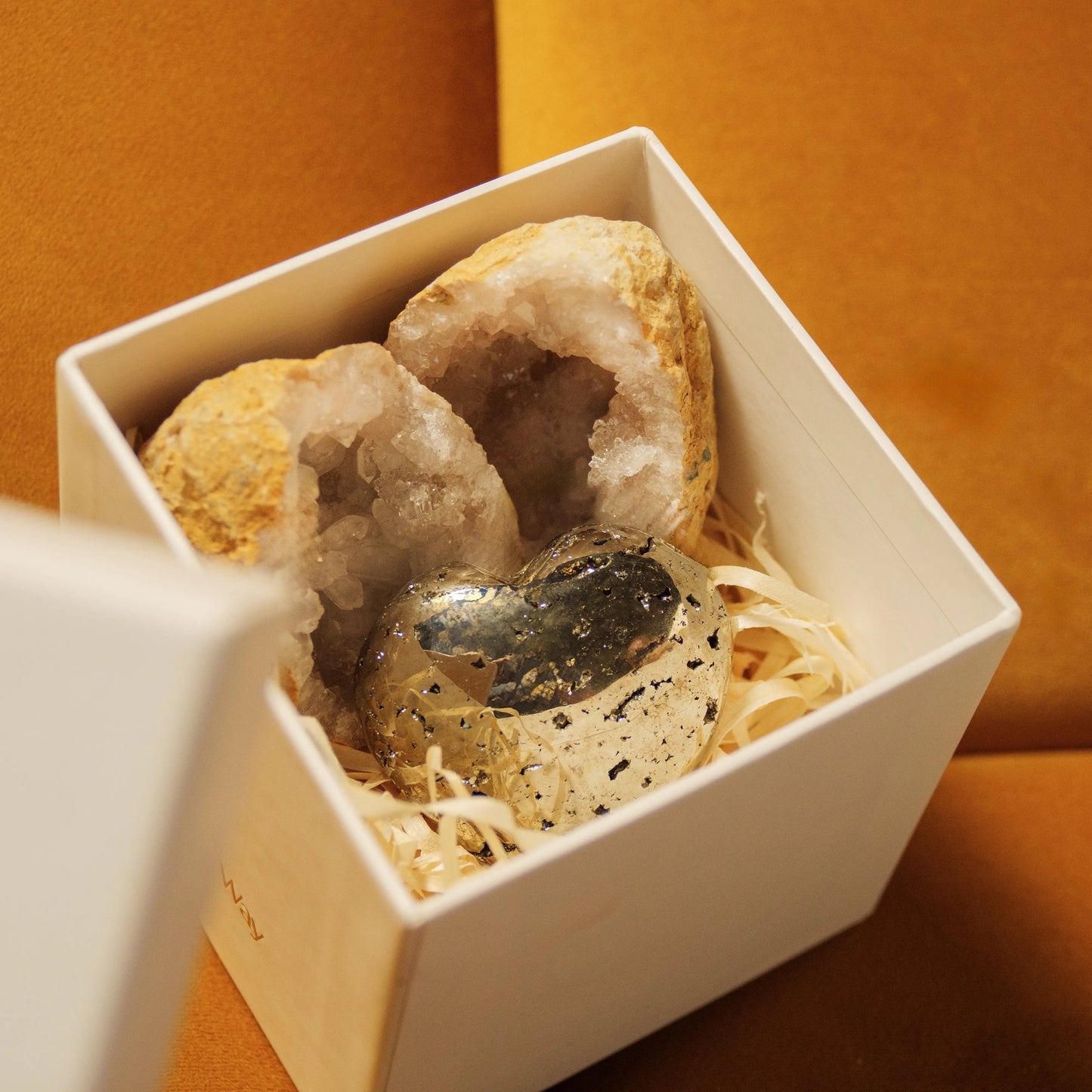 Quartz Geode and Pyrite Heart in Abundant Love Gift Box for Valentine's Day on textured backdrop.
