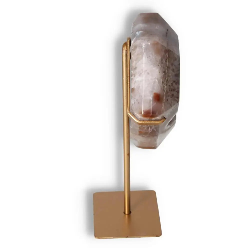Side view of agate decoration with stand, showcasing natural patterns and crystalline textures on a polished surface.