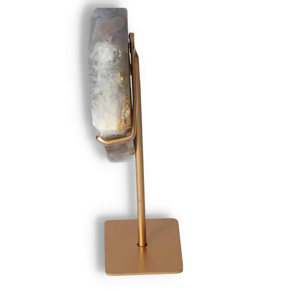 Side view of an agate decoration on a gold stand showcasing natural patterns and crystalline formations for elegant home decor.