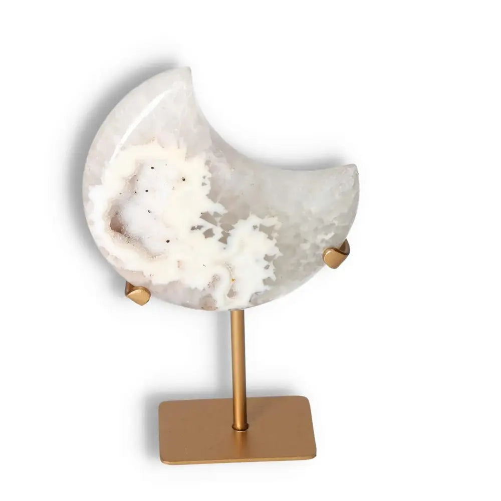 Agate lunar crescent sculpture with ethereal swirls and geode center on a gold stand, illuminating elegance and natural beauty.