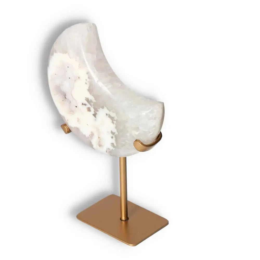 Agate lunar crescent sculpture with swirling off-white hues on a gold stand, showcasing the ethereal beauty and natural artistry of agate.