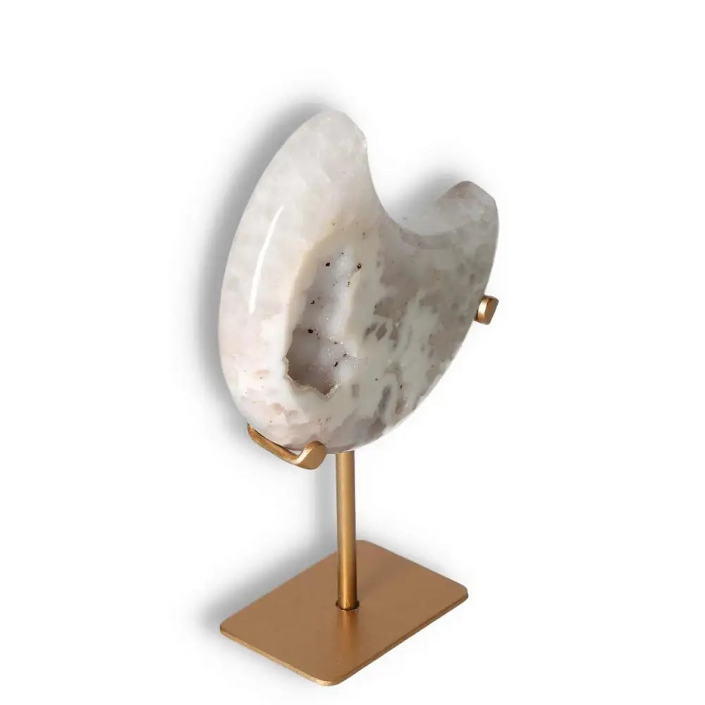 Agate lunar crescent sculpture with natural geode, showcasing translucent swirls in soft hues on a gold stand, ideal for home décor.