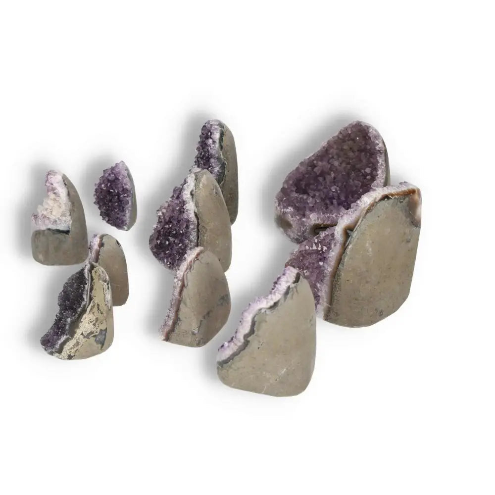Assorted amethyst cut base geodes from Sylvia Crystals, 0.1-1 kg, showcasing purple crystal interior and natural rock exterior for spiritual decor.