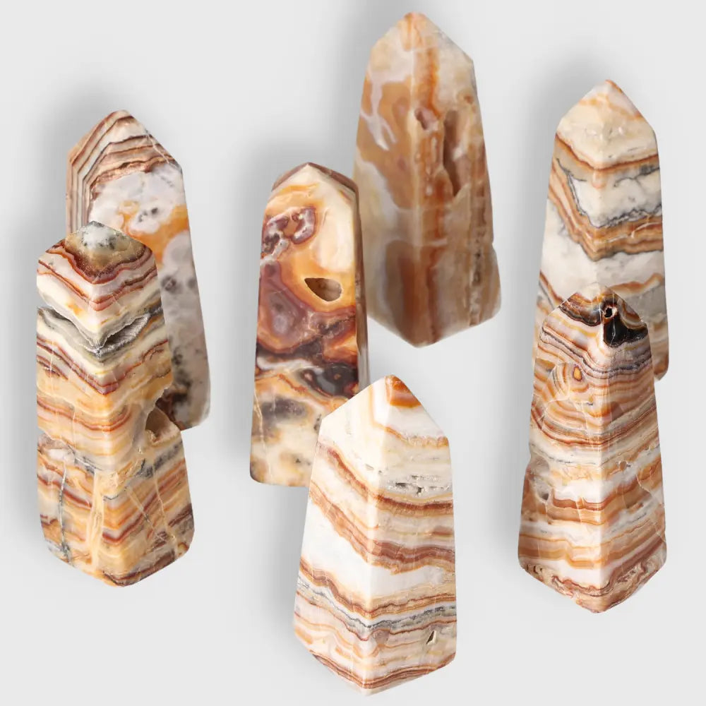 Group of natural brown aragonite crystal towers featuring earthy tones and stabilizing energies for metaphysical enhancement.