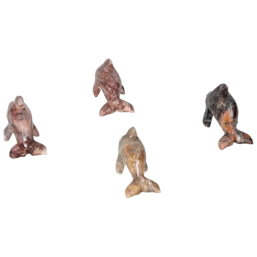 Four carved magnesite dolphin figurines showcasing their unique textures and colors, ideal for enhancing meditation spaces and home decor.