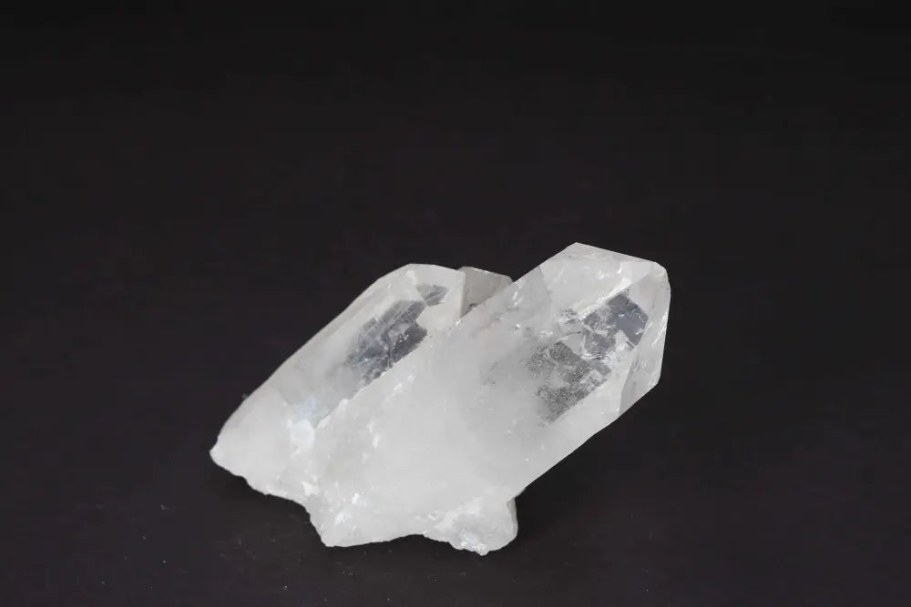 Clear Quartz Cluster with multiple crystal points on a black background, radiating purity and high vibrational energy.