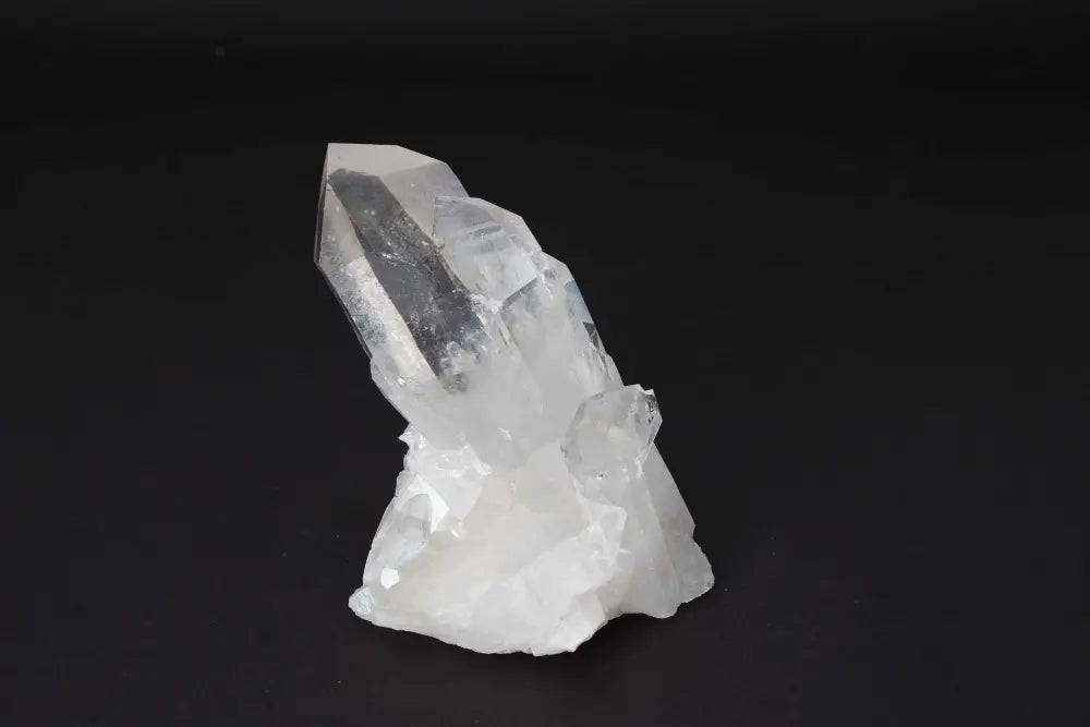 Clear Quartz Cluster on dark background, radiating clarity and high vibrational energy, ideal for amplifying intention and purifying spaces.