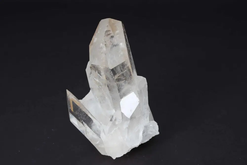 Clear Quartz Cluster crystal formation on dark background, radiating pure energy and amplifying vibrations for space harmony.