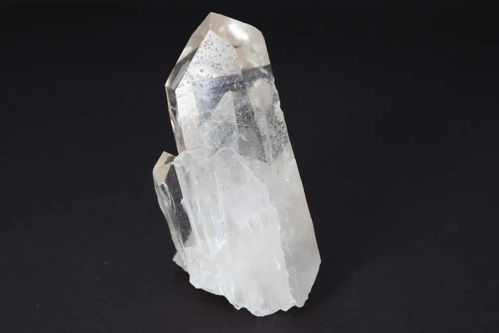 Clear Quartz Cluster with multiple crystal points, amplifying energy and radiating clarity and harmony on a black background.