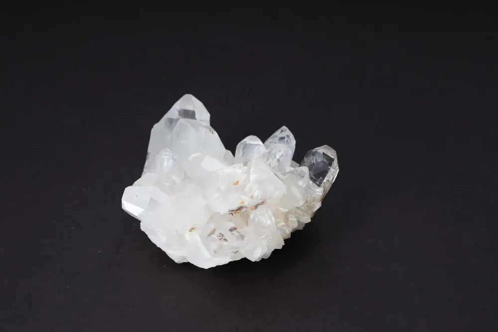 Clear Quartz Cluster with multiple crystal points on a dark background, amplifying energy and intention.