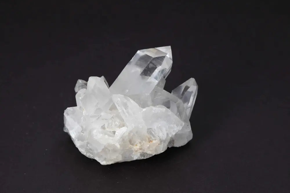 Clear Quartz Cluster on black background, showcasing multiple crystal points and natural formation; radiates purity and energy amplification.