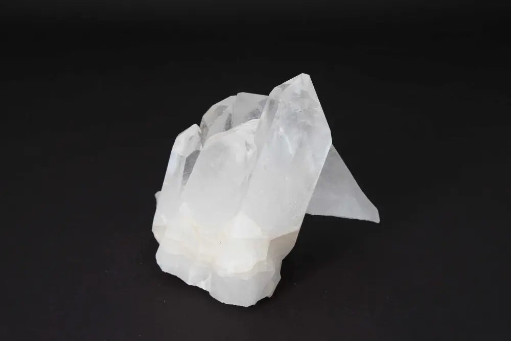 Clear Quartz Cluster with multiple crystal points on a dark background, radiating purity and high vibrational energy.