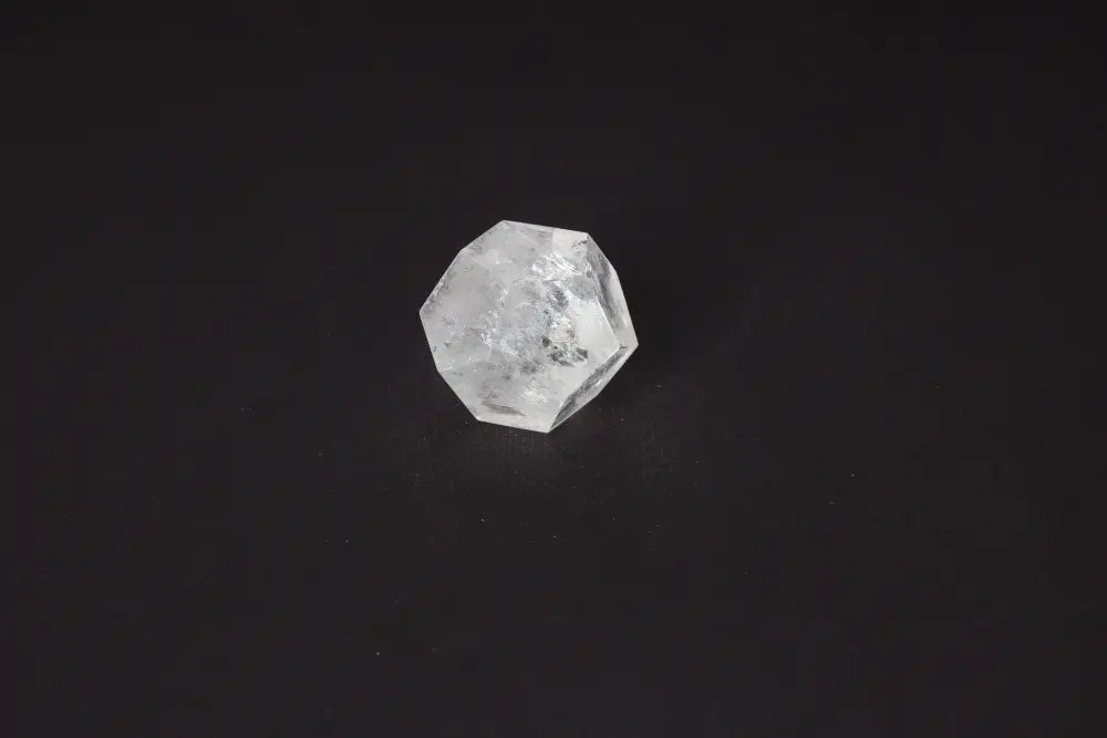 Clear Quartz Geometric Sphere 5 cm on black background, a powerful stone for purification and harmonizing energy.