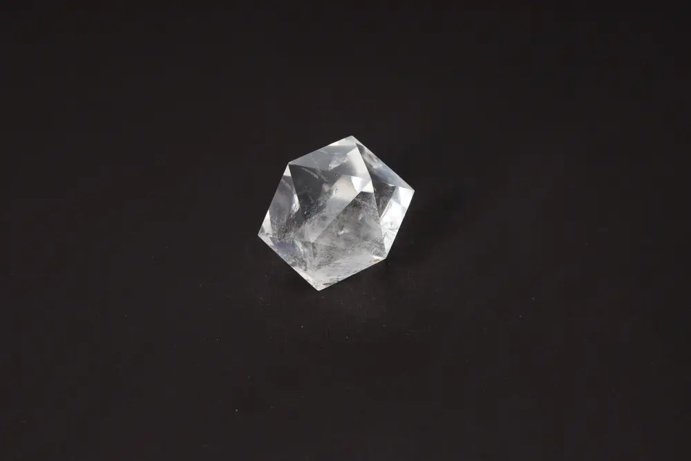 Clear Quartz Geometric Sphere 5 cm for energy harmonization and purification with absorption of negative vibrations on black background.