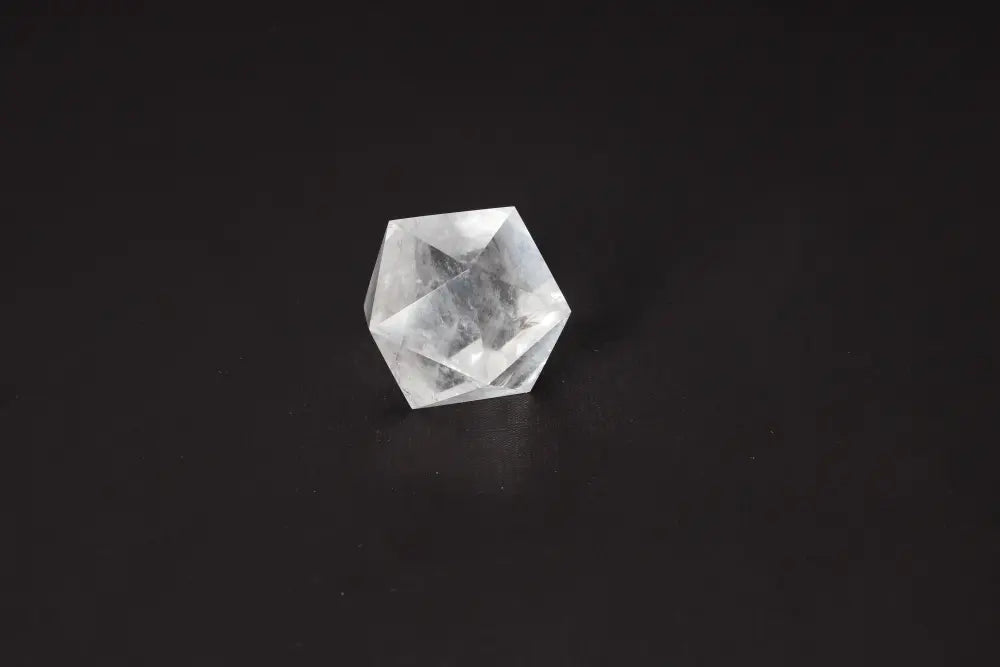 Clear Quartz Geometric Sphere 5 cm on black background, known for purification and energy harmonizing properties, dispelling negative vibes.