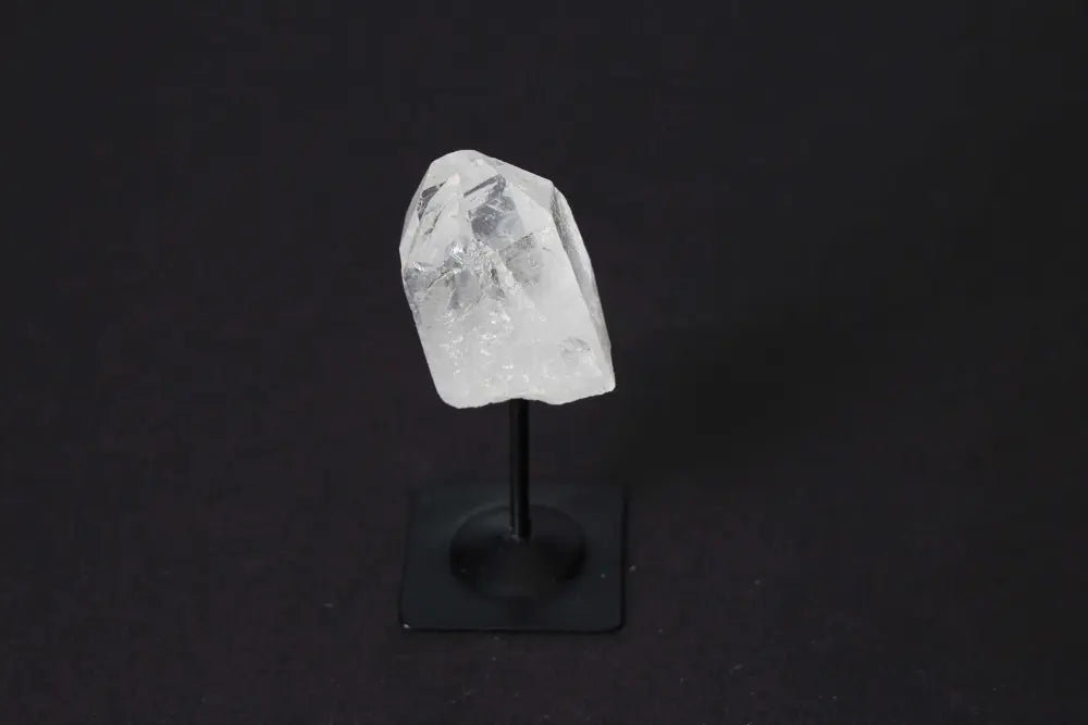 Clear Quartz crystal on metal stand against dark background, luxurious decor from Sylvia Crystals.