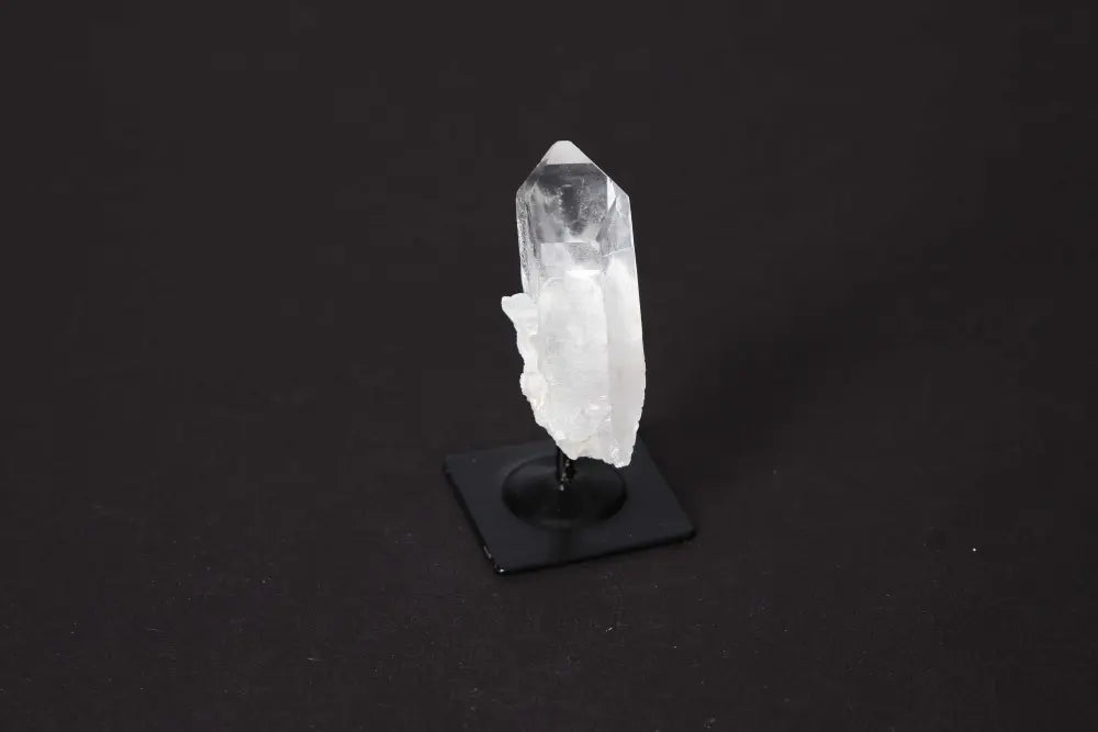 Clear Quartz crystal on a metal stand, perfect for home decor and spiritual focus, known for energy amplification and harmonization.
