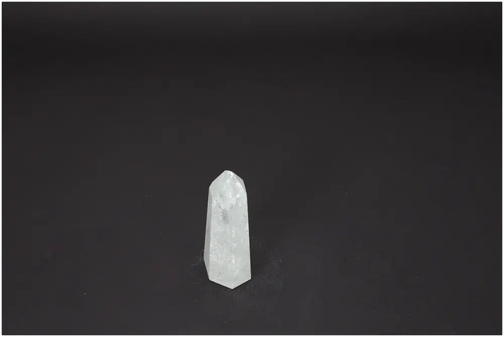 Lemurian Quartz Obelisk on dark background, showcasing its clarity and unique spiritual properties.