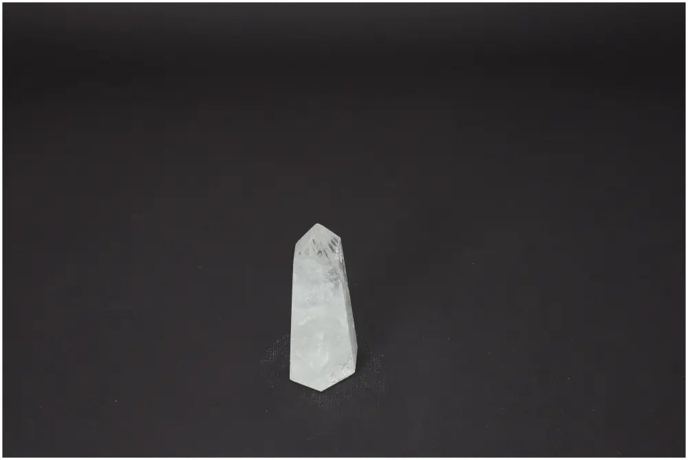 Lemurian Quartz Obelisk on dark background, a crystal with unique properties, enhancing chakra energy and aligning with zodiac signs.