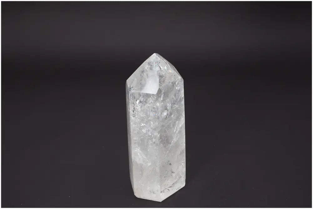 Clear Lemurian Quartz Obelisk standing against a black background, showcasing unique crystal clarity and energetic properties.