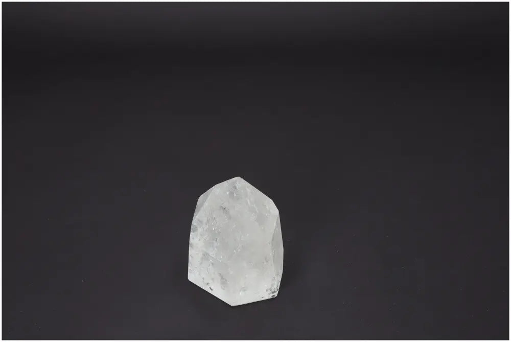 Lemurian Quartz Obelisk on dark background, showcasing unique properties for chakras and zodiac signs.