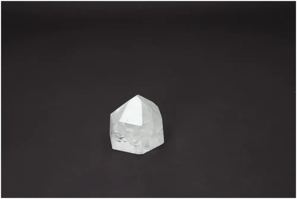 Polished Lemurian Quartz Obelisk on dark background, highlighting energetic properties linked with chakras and zodiac signs.