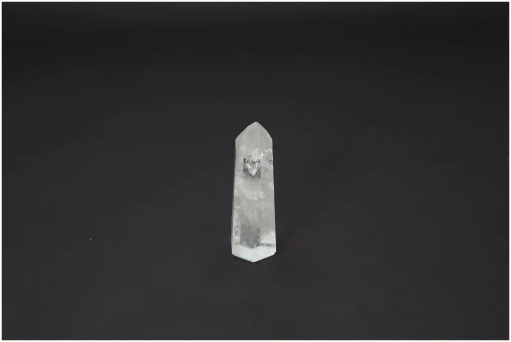 Lemurian Quartz Obelisk against dark background, featuring natural clarity and spiritual properties, linked to chakras and zodiac signs.