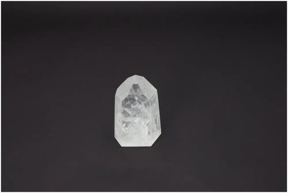 Lemurian Quartz Obelisk against a dark background, known for its spiritual properties and chakra alignment.