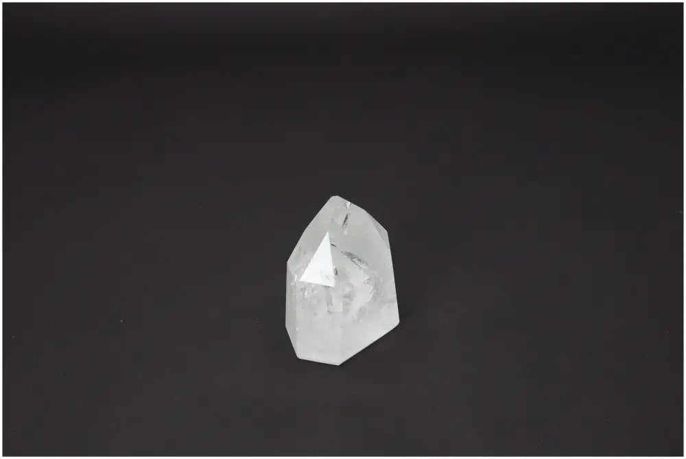 Lemurian Quartz Obelisk against a dark background, showcasing its clarity and facets. Ideal for chakra healing and spiritual energy work.