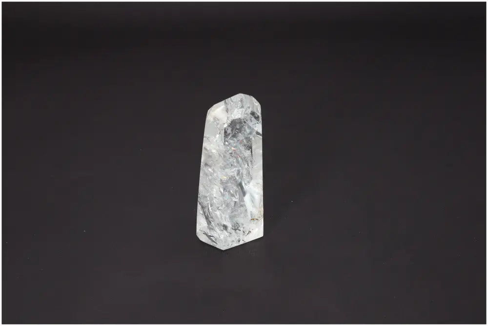 Lemurian Quartz Obelisk with varied quartz properties, aligning chakras and supporting spiritual needs against a dark background.