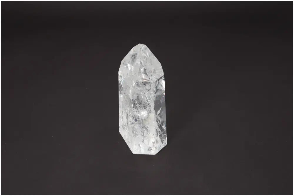 Lemurian Quartz Obelisk crystal on a dark background, showcasing its clear, multifaceted structure and spiritual energy properties.