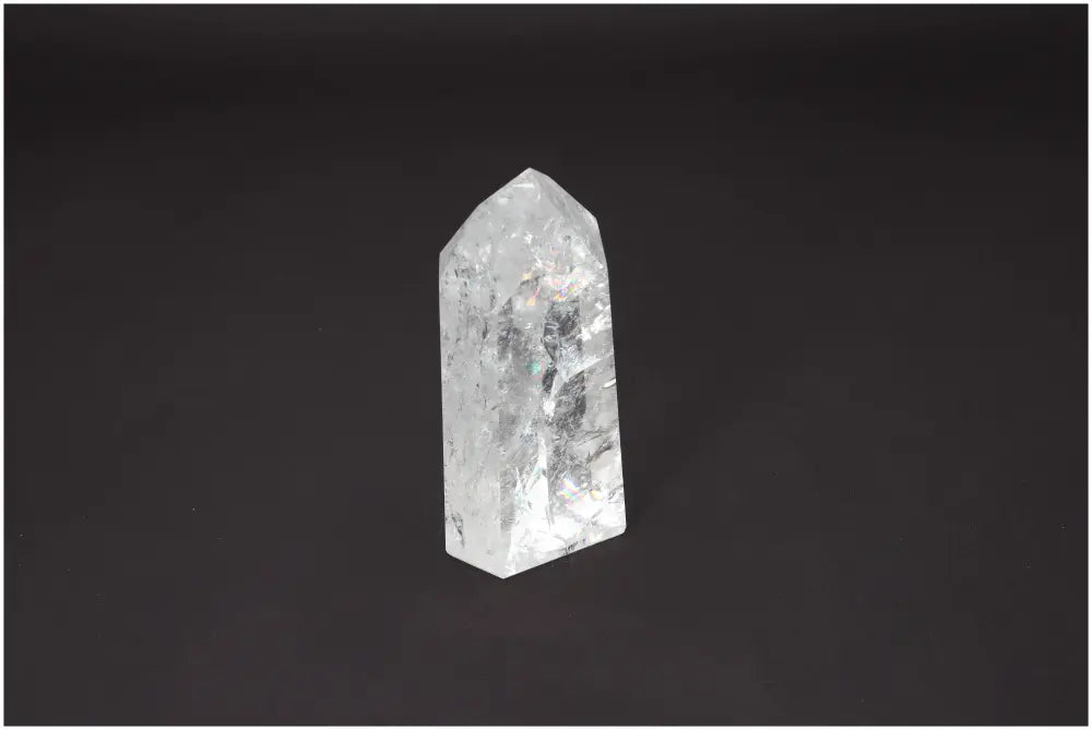 Lemurian Quartz Obelisk on dark background, showcasing its clarity and spiritual energy properties. Ideal for chakra and zodiac alignment.