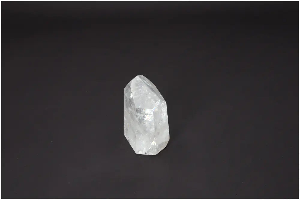 Lemurian Quartz Obelisk with unique properties enhancing chakra alignment and spiritual energy, clear crystal on a dark background.
