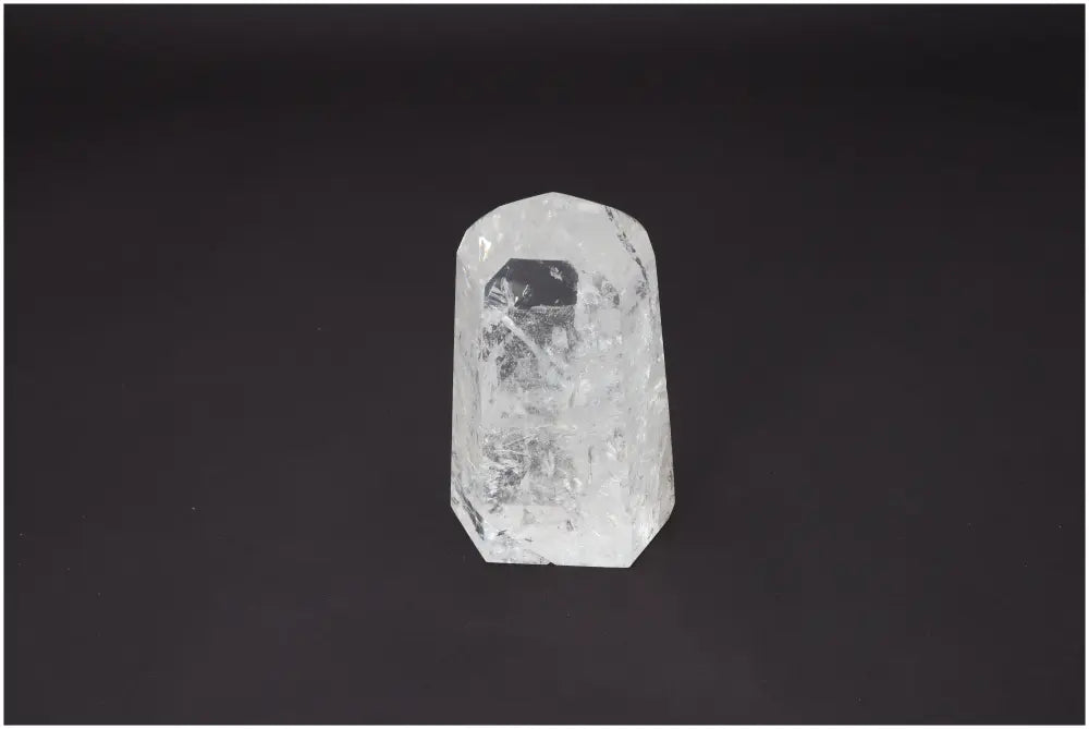Lemurian Quartz Obelisk on black background, known for its unique properties affecting body and soul, linked to chakras and zodiac signs.