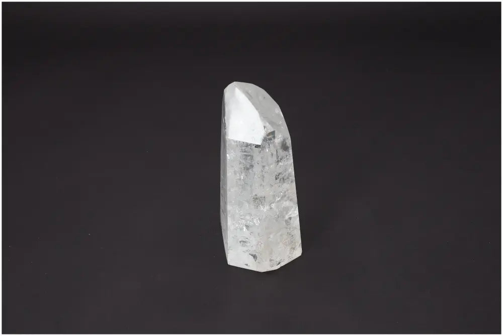 Lemurian Quartz Obelisk on black background, known for unique properties affecting body and soul, linked to chakras and zodiac signs.