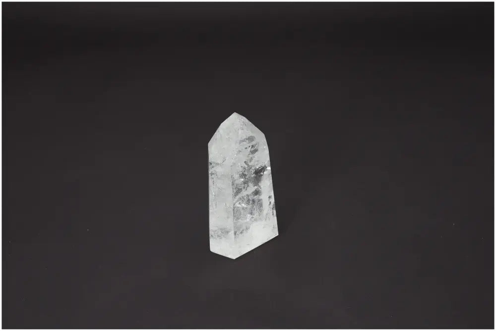 Lemurian Quartz Obelisk for chakra and zodiac alignment on a dark background.