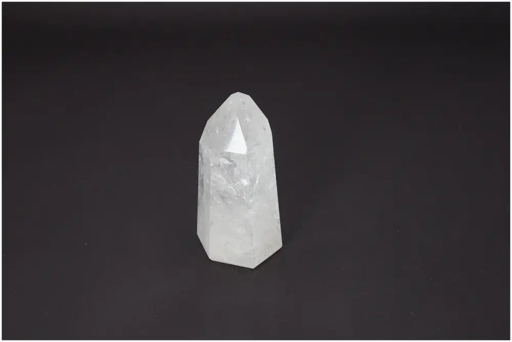 Lemurian Quartz Obelisk on dark background, showcasing unique properties for chakras and zodiac alignment.