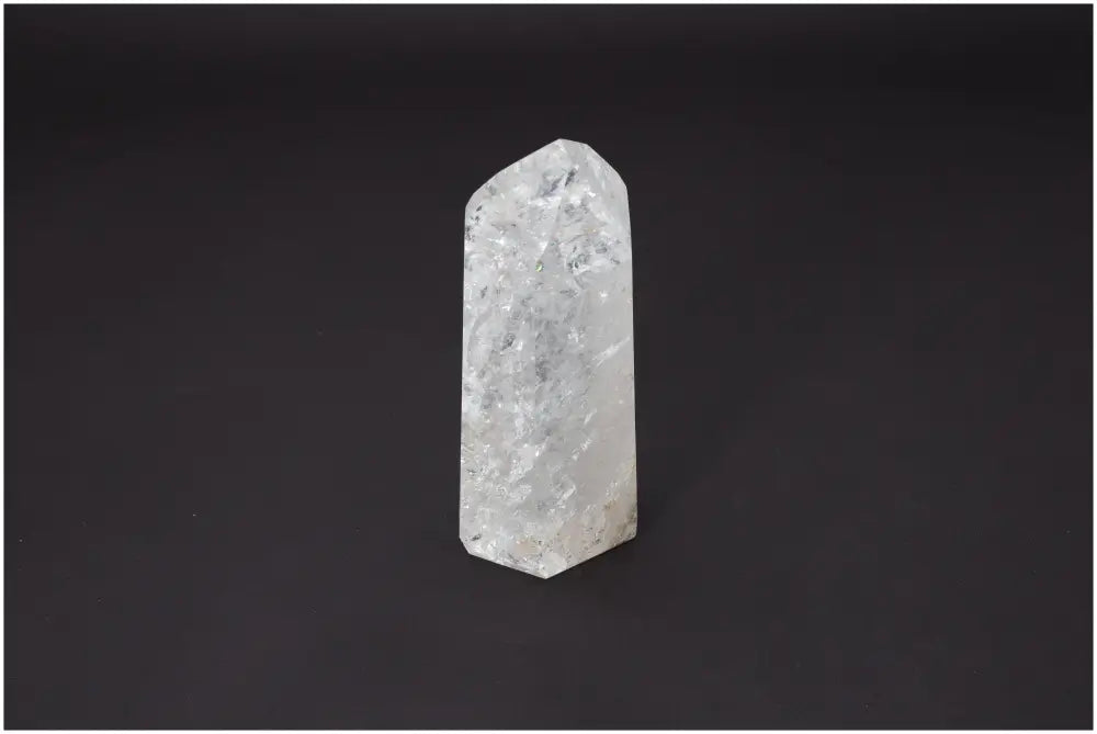 Lemurian Quartz Obelisk with unique properties enhancing chakras and zodiac alignment against a dark background.