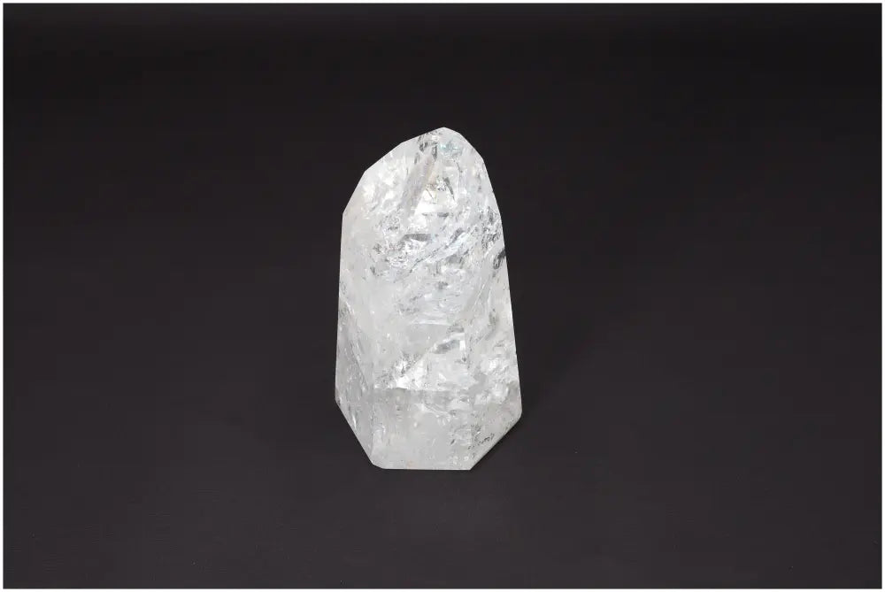 Lemurian Quartz Obelisk on dark background showcasing its clear crystalline structure for chakra and zodiac energy alignment.
