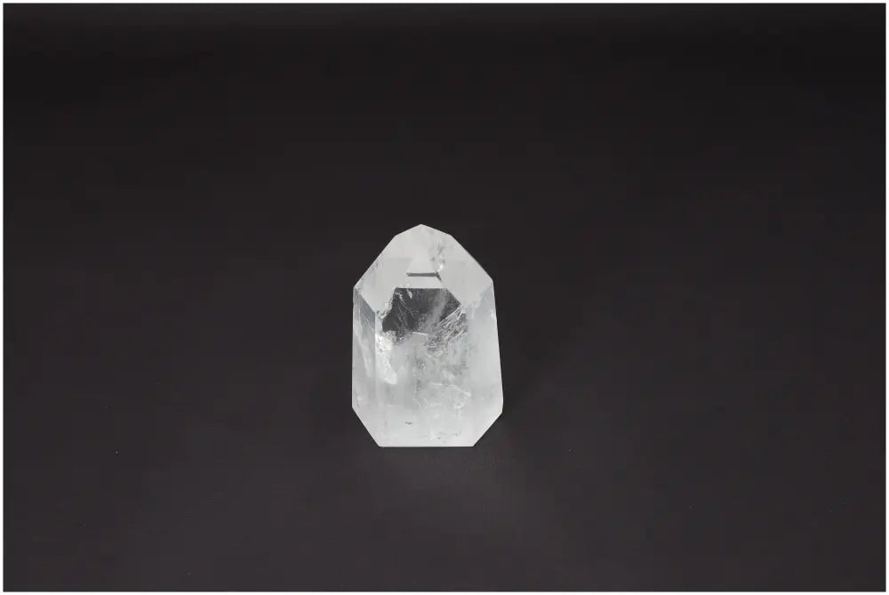 Clear Lemurian Quartz Obelisk against dark background, ideal for clarity and healing energy. Ethically sourced crystal.