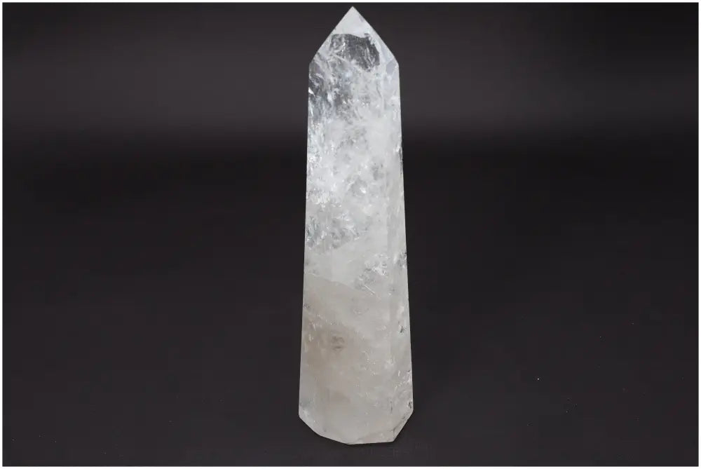Lemurian Quartz Obelisk on black background, a clear crystal known for healing and energy amplification, hand-selected and ethically sourced.
