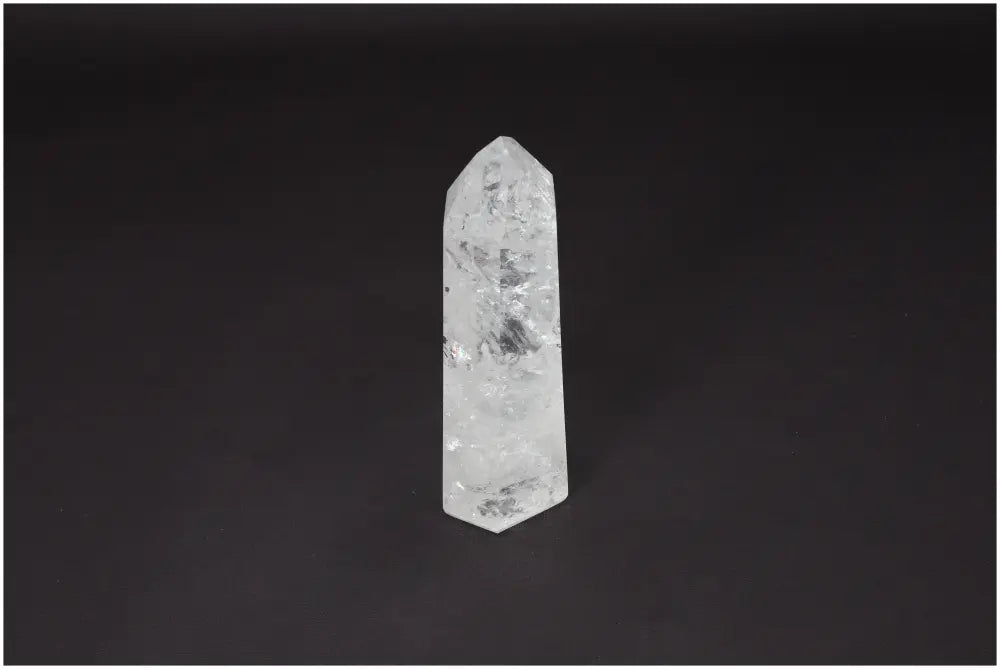 Lemurian Quartz Obelisk crystal standing against a dark background, known for clarity, balance, and personal growth enhancement.