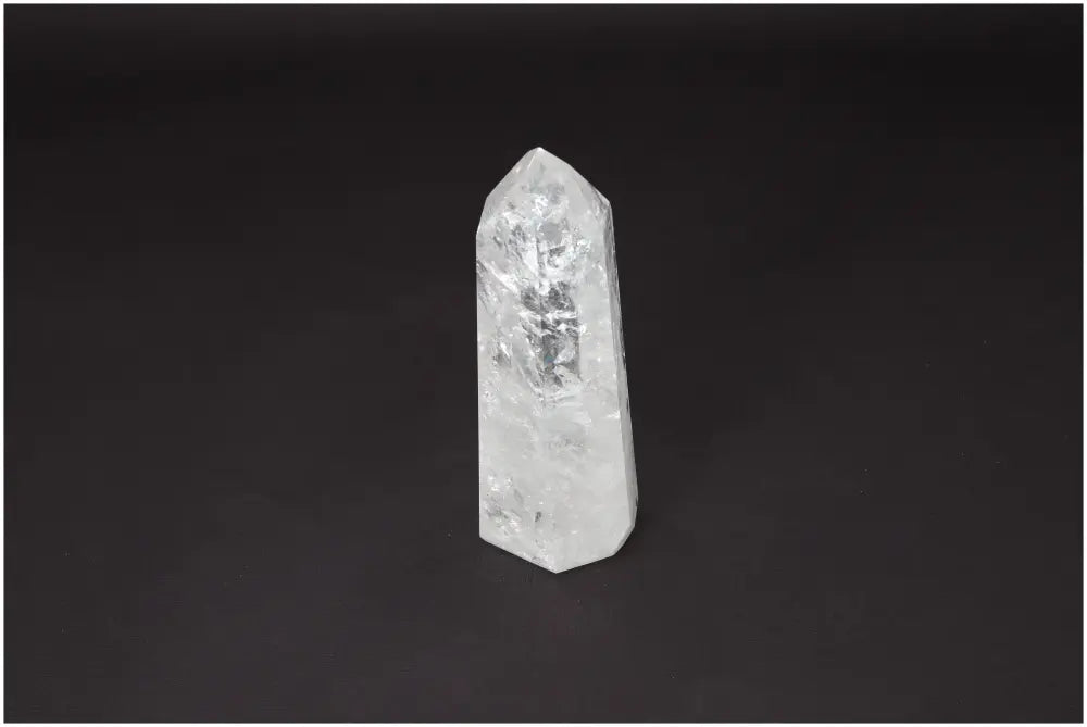 Lemurian Quartz Obelisk on a dark background, a clear crystal known as the Master Healer for enhancing clarity and balance.