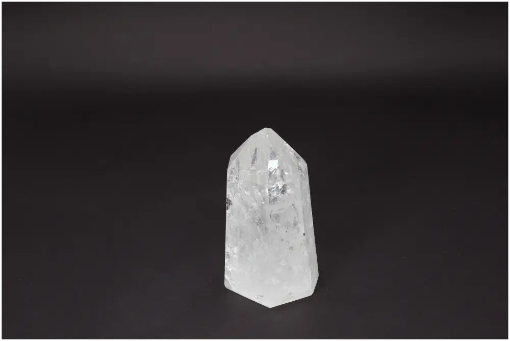 Lemurian Quartz Obelisk standing against a dark background, known for clarity and balance, ethically sourced and naturally formed.