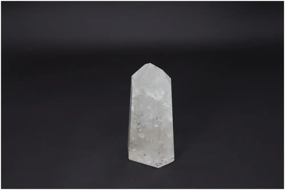 Clear Lemurian Quartz Obelisk on black background, known for its healing properties and energy amplification.