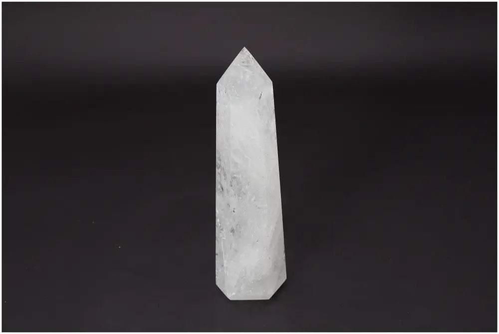 Lemurian Quartz Obelisk against dark background, clear quartz known as the Master Healer for energy amplification and personal growth.