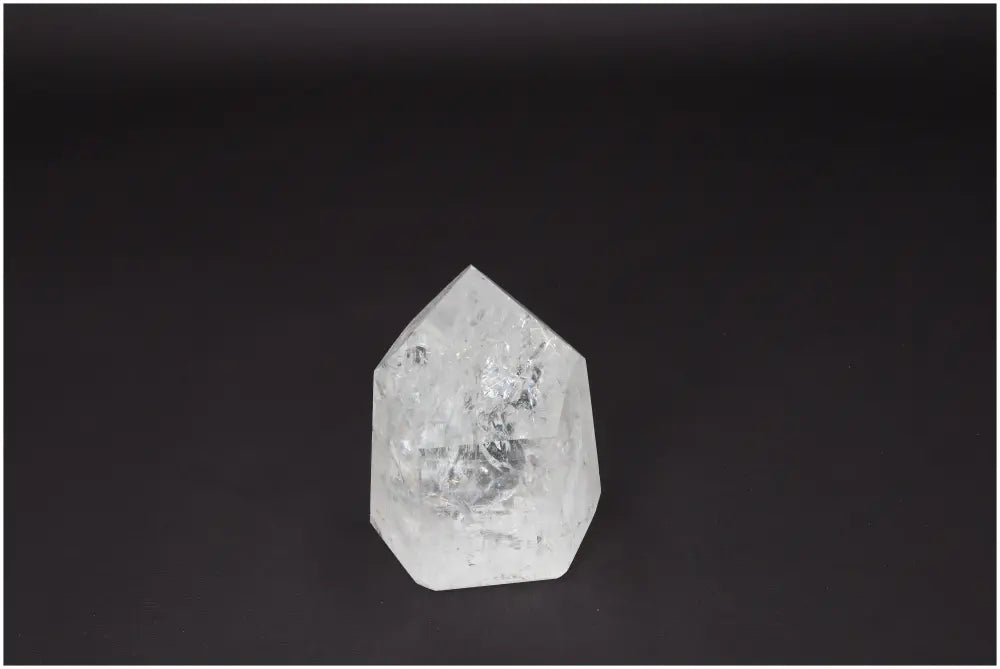 Lemurian Quartz Obelisk on dark background, known for clarity and healing properties; ethically sourced and naturally formed crystal.