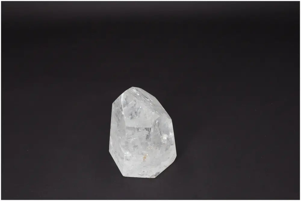 Clear Lemurian Quartz Obelisk on dark background for healing and balance.